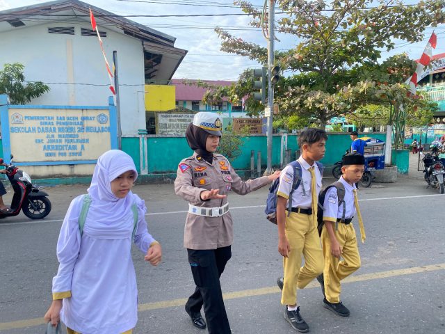 Personel sat Lantas membantu pelajar buat menyeberangi jalan