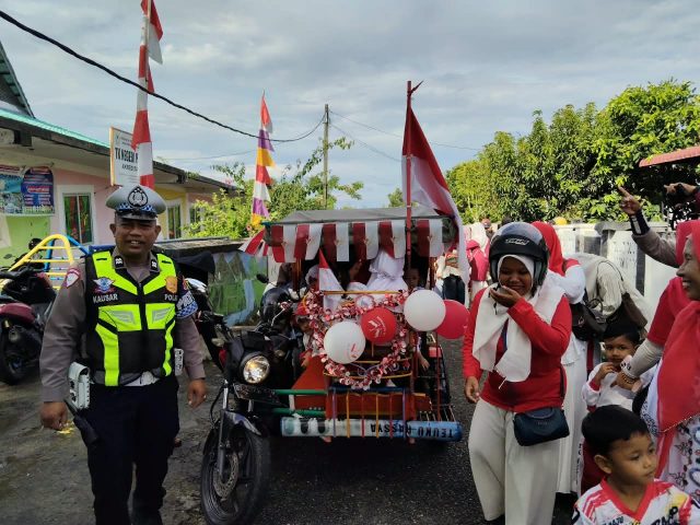 Personel Satlantas Polres Aceh Barat mengawal pawai becak hias murid TK Negeri Pembina di Jalan Syahkuala, Gampong Kuta Padang, Johan Pahlawan, Kamis (13/8/2026). Dok. Polres Aceh Barat.