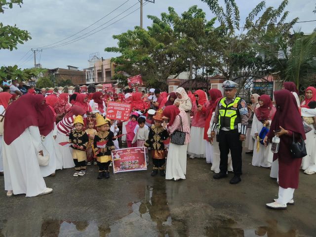 Personel Satlantas Polres Aceh Barat mengawal pawai murid TK Raudhatul Athfal menyambut HUT ke-81 RI di Jalan Imam Bonjol, Johan Pahlawan, Jumat (14/8/2026). Dok. Polres Aceh Barat.