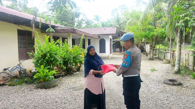 Personel Polsek Kaway XVI membagikan bendera Merah Putih kepada warga menjelang HUT ke-81 Kemerdekaan RI di Kecamatan Kaway XVI, Aceh Barat, Jumat (14/8/2026). Dok. Polres Aceh Barat.