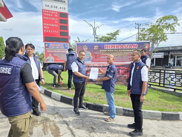 Personel Unit Tipidter Satreskrim Polres Aceh Barat memasang spanduk dan memperkuat komitmen integritas petugas SPBU dalam penyaluran BBM sesuai ketentuan. Rabu (28/10/2026) Dok. Polres Aceh Barat